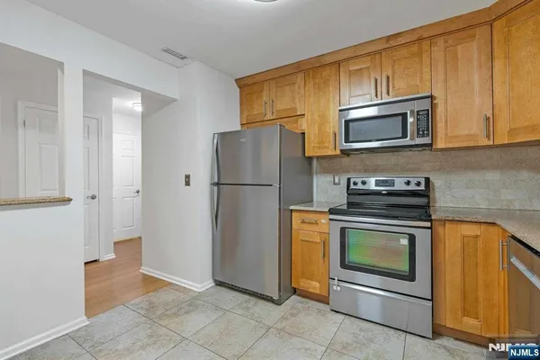 a kitchen with stainless steel appliances granite countertop a refrigerator stove and microwave