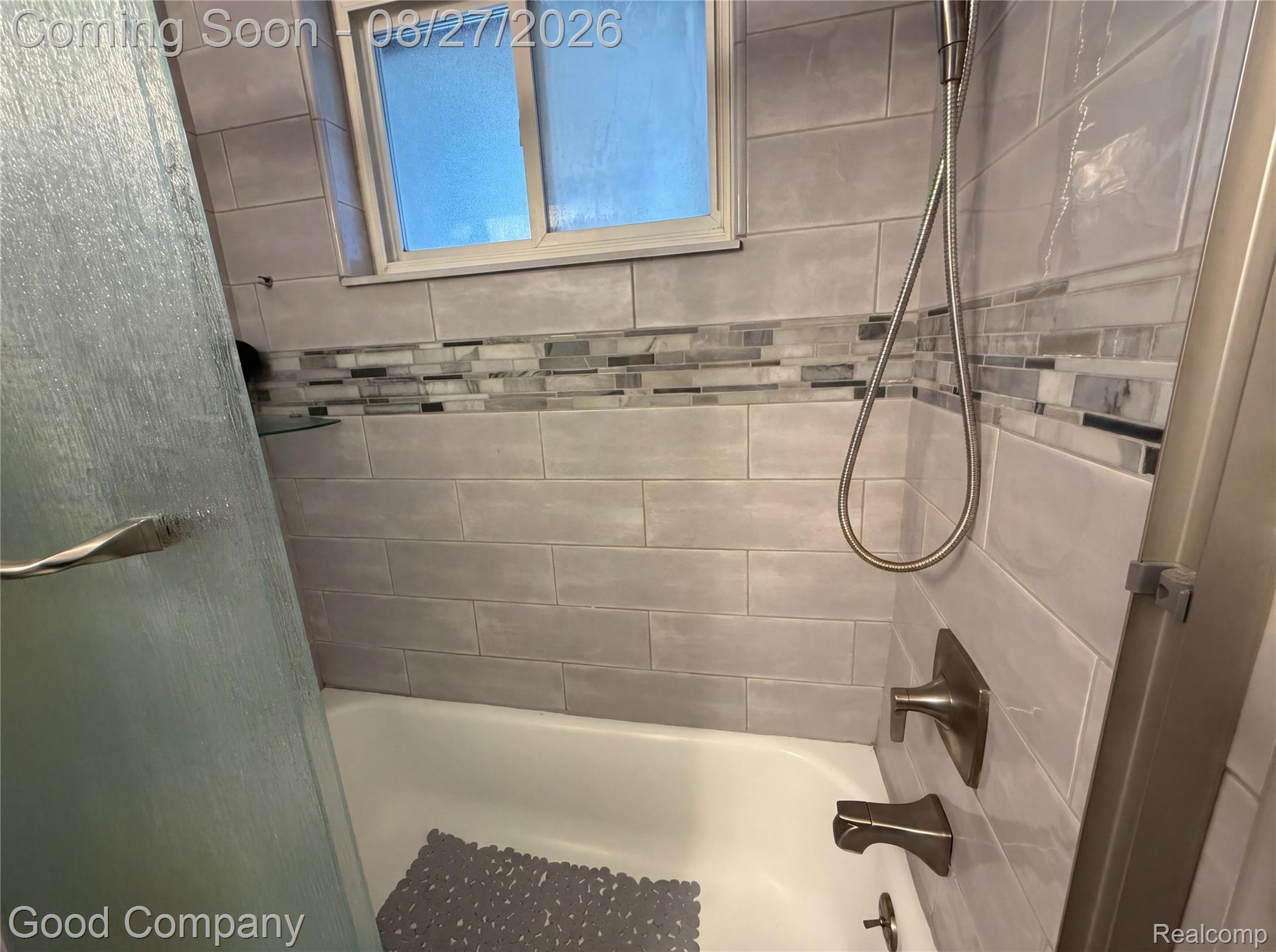 17941 East 13 Mile Road Fraser, MI 48026 - Photo 11 of 32 Bathtub with light gray subway tile surround, mosaic accent tile, and bronze-finish fixtures