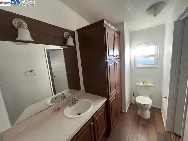 a bathroom with a granite countertop sink a toilet and a large mirror