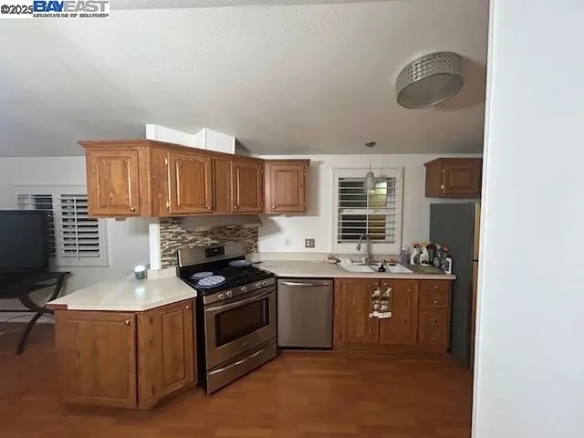 a kitchen with stainless steel appliances granite countertop a stove and a sink
