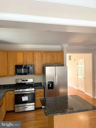 a kitchen with granite countertop a refrigerator and a stove