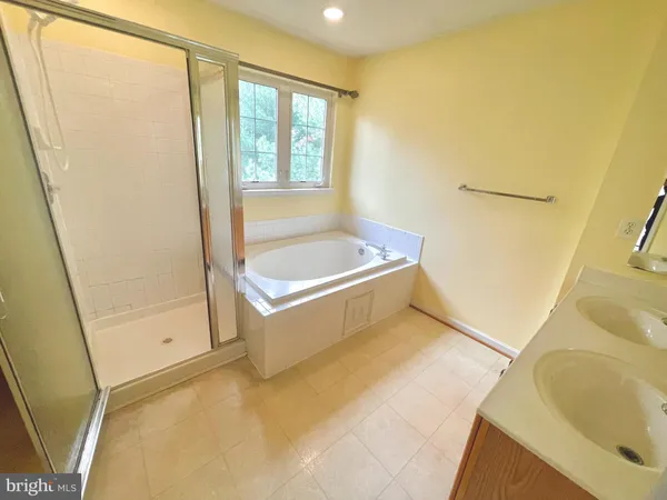a view of kitchen and empty room with wooden floor