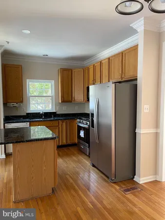 a kitchen with stainless steel appliances granite countertop a refrigerator a sink and a stove