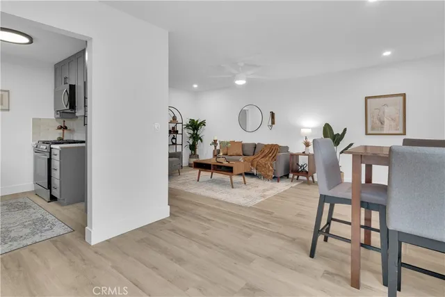 a living room with furniture a wooden floor and a refrigerator