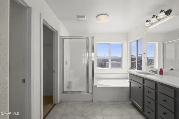 a large bathroom with a double vanity sink a large mirror and a bathtub