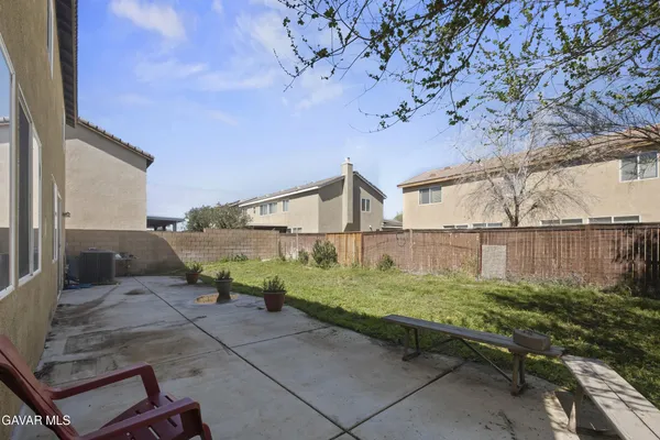 a backyard of a house with plants and outdoor seating