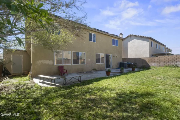 a backyard of a house with table and chairs