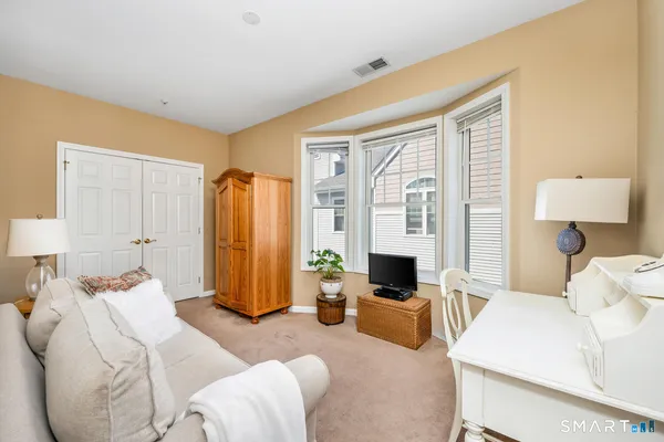 a bedroom with furniture and a large window