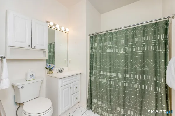 a bathroom with a toilet sink vanity and tub