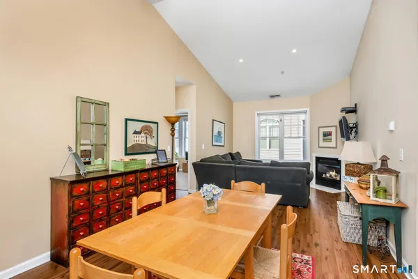a living room with furniture a flat screen tv and a dining table