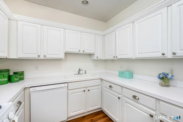 a kitchen with white cabinets and white appliances