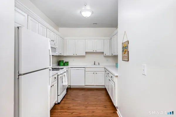 a kitchen with white cabinets and white appliances