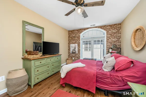 a bedroom with a bed and wooden floor