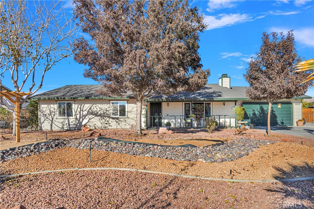22164 Cholena Road Apple Valley, CA 92307 - Photo 1 of 1 a front view of a house with a yard covered with trees
