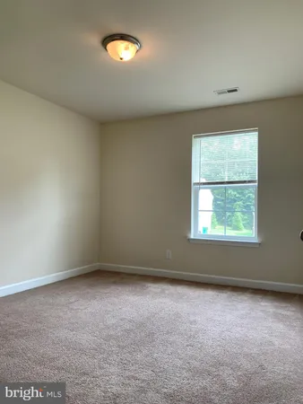 an empty room with windows and chandelier fan