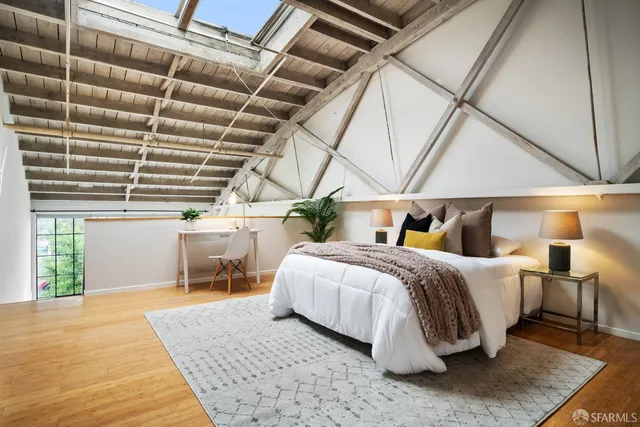 a bedroom with a bed a table and painting on the wall