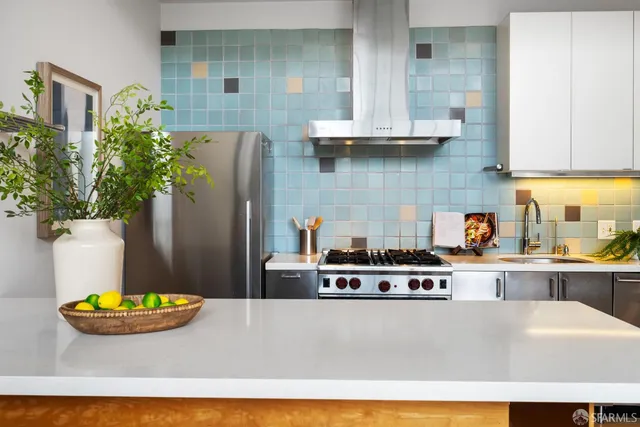 a living room with stainless steel appliances kitchen island granite countertop a sink a stove and refrigerator