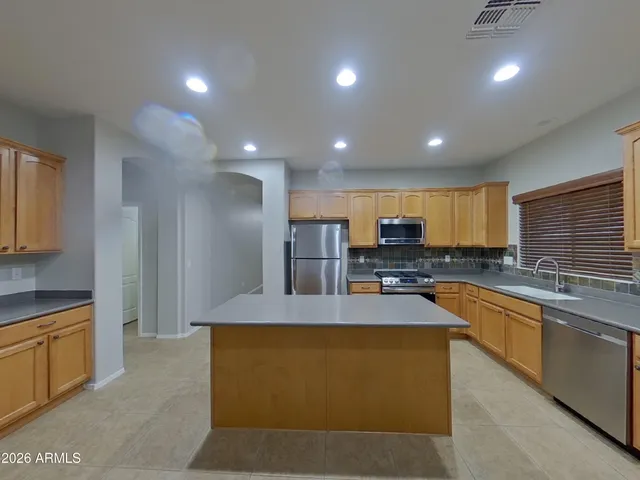 a large kitchen with stainless steel appliances granite countertop a large counter top and a stove