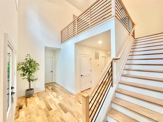a view of a hallway to a house with wooden floor and stairs