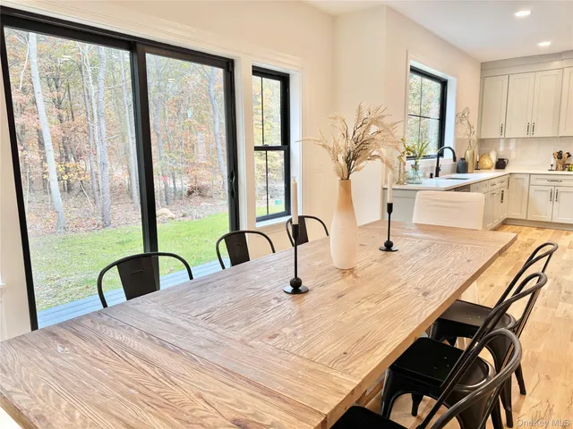 a bedroom with a bed a table and large windows with sink