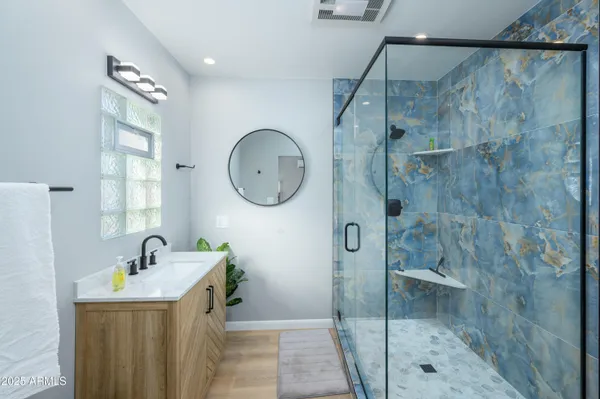 a bathroom with a sink a mirror and a shower