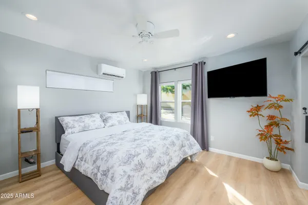 a bedroom with a bed and a flat screen tv