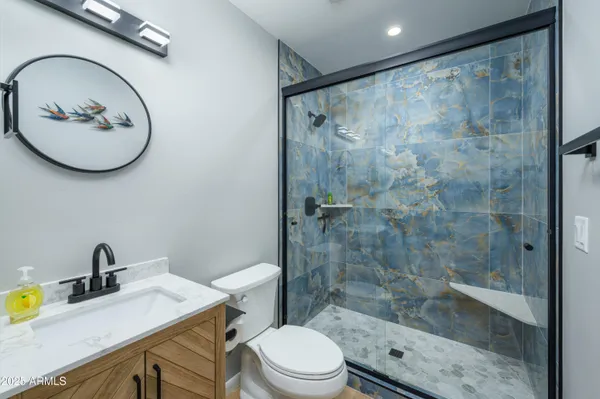 a bathroom with a sink mirror toilet and shower