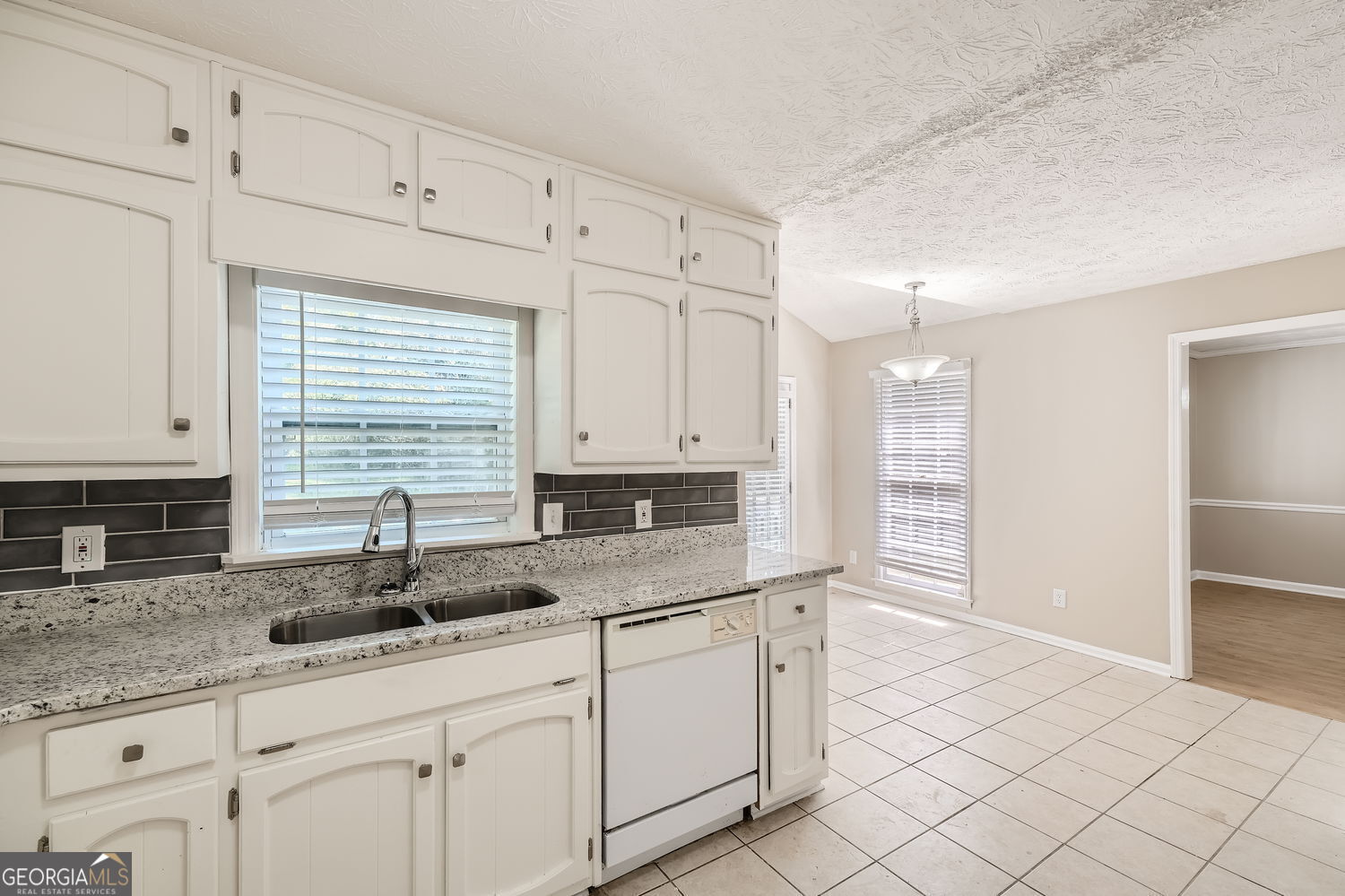 849 Ridge Avenue Stone Mountain, GA 30083 - Photo 5 of 11 a kitchen with granite countertop a sink white cabinets and a window