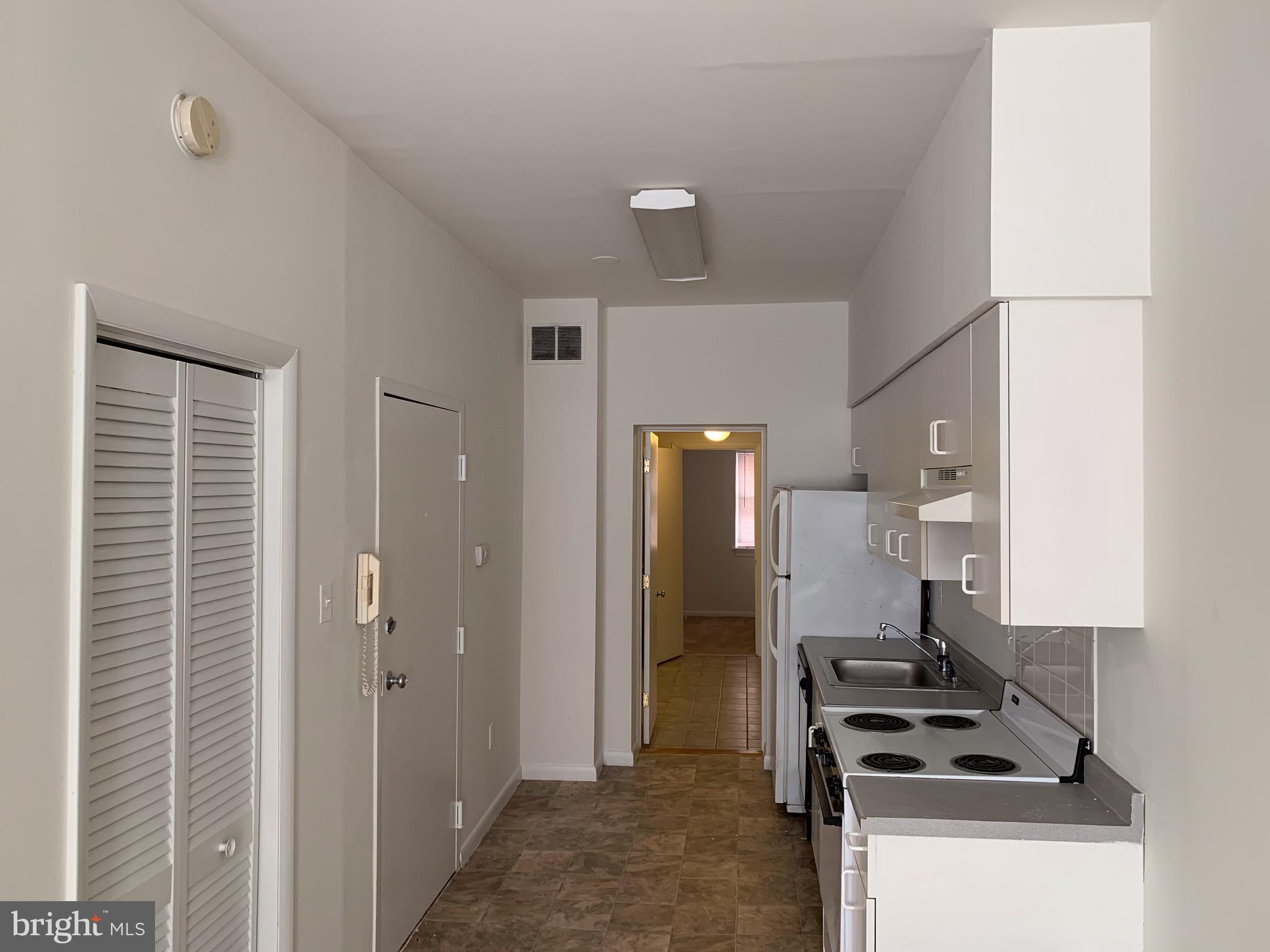 1203 Locust Street, Unit 1F Philadelphia, PA 19107 - Photo 3 of 15 a kitchen with a refrigerator and a stove top oven