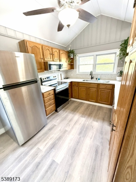 62 Wolfe Road, Unit 63 Budd Lake, NJ 07828 - Photo 3 of 19 a kitchen with a refrigerator a sink and dishwasher with wooden floor