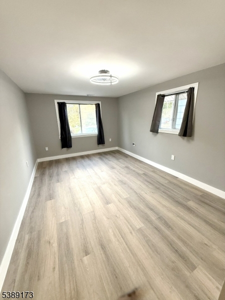 62 Wolfe Road, Unit 63 Budd Lake, NJ 07828 - Photo 5 of 19 an empty room with wooden floor and windows