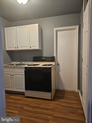 a kitchen with granite countertop a stove microwave and a sink