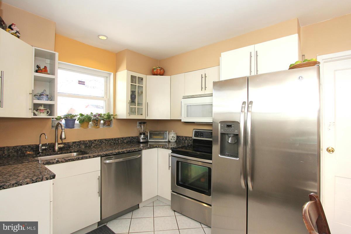 224 University Boulevard East Silver Spring, MD 20901 - Photo 11 of 30 a kitchen with a sink a refrigerator and cabinets