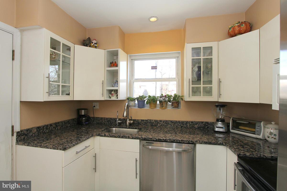 224 University Boulevard East Silver Spring, MD 20901 - Photo 12 of 30 a kitchen with stainless steel appliances granite countertop a sink stove and cabinets