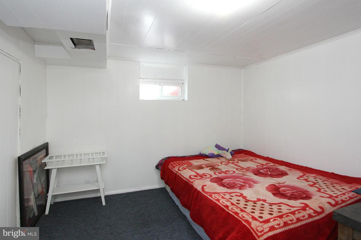 224 University Boulevard East Silver Spring, MD 20901 - Photo 25 of 30 a bedroom with a bed and a lamp on the dresser