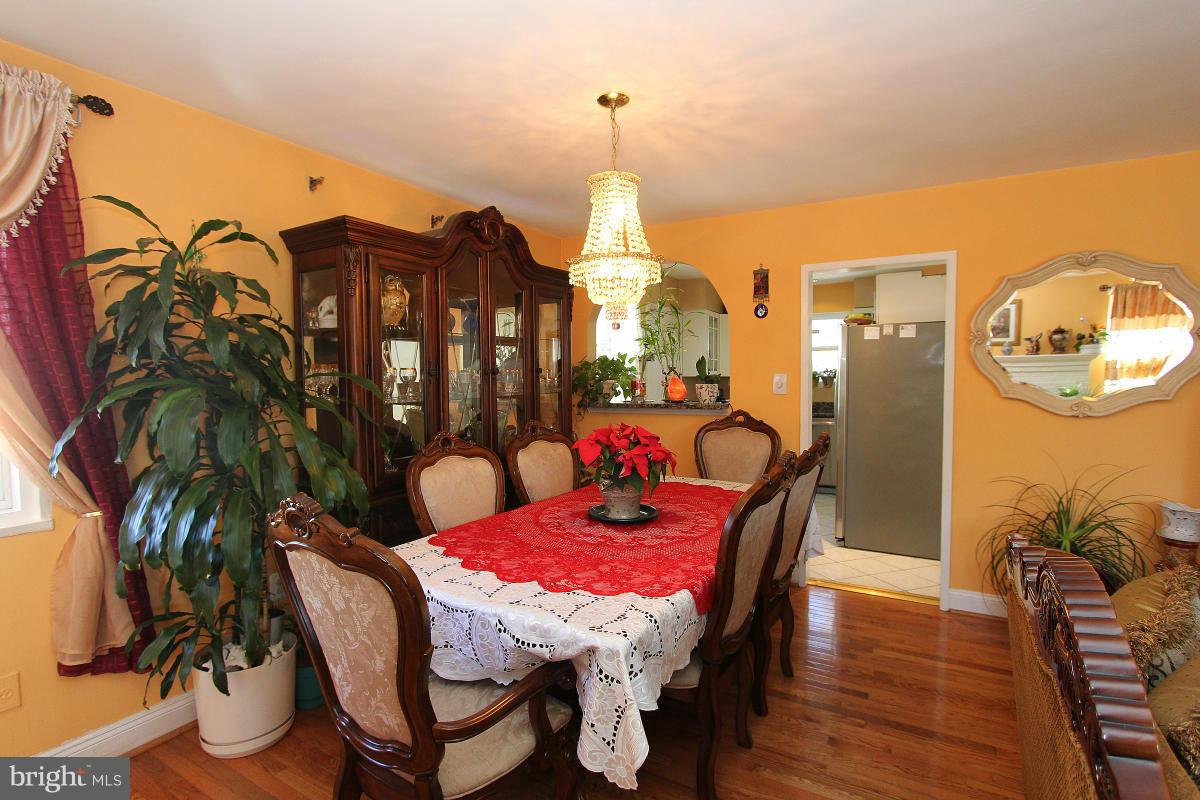 224 University Boulevard East Silver Spring, MD 20901 - Photo 6 of 30 a dining room with furniture a potted plant and wooden floor
