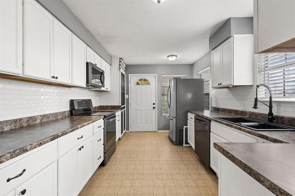 1223 Yowell Road Whitesboro, TX 76273 - Photo 5 of 30 a kitchen with stainless steel appliances granite countertop a stove a sink and a refrigerator