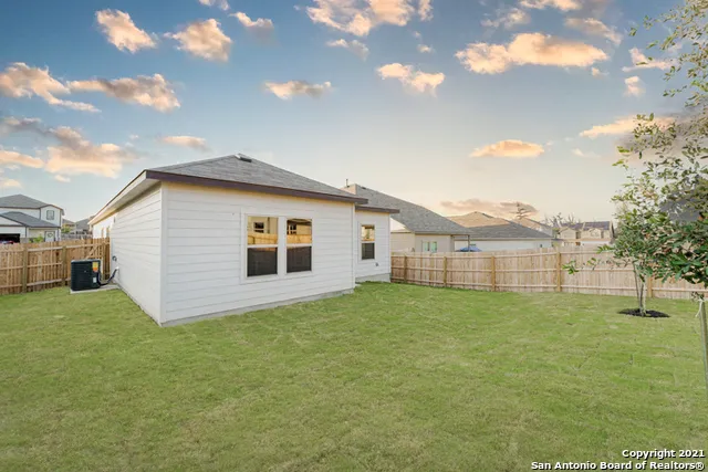 a view of backyard of house with green space