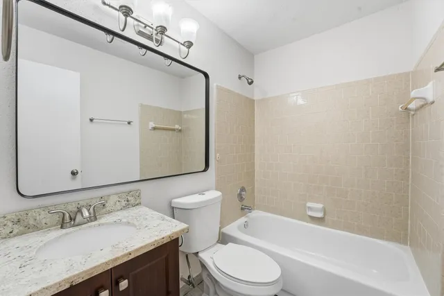 a bathroom with a granite countertop sink toilet and shower