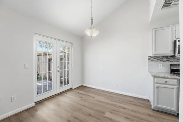 a view of a kitchen with wooden floor and a window
