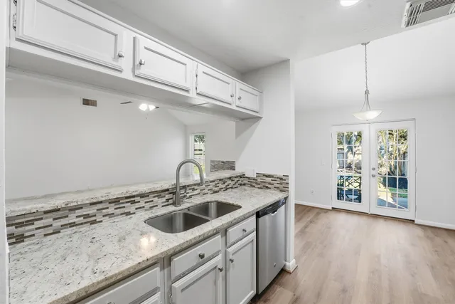 a kitchen that has a sink a stove and cabinets
