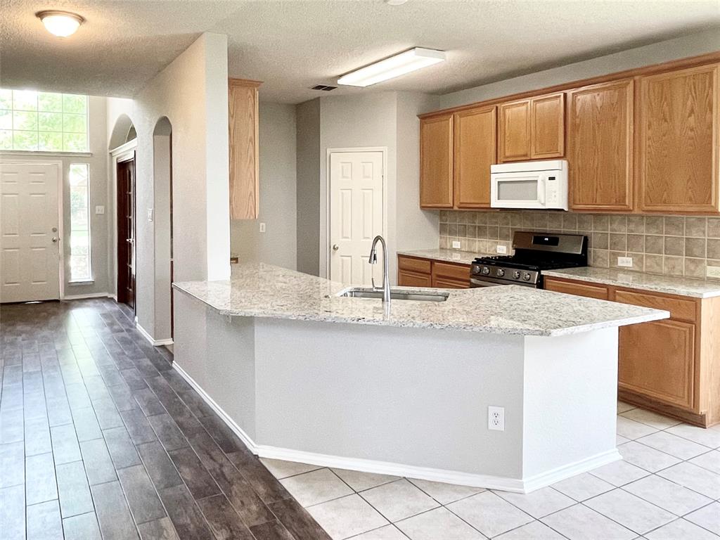 7205 Prairie Flower Lane Frisco, TX 75033 - Photo 6 of 23 a kitchen with stainless steel appliances granite countertop a sink stove and cabinets