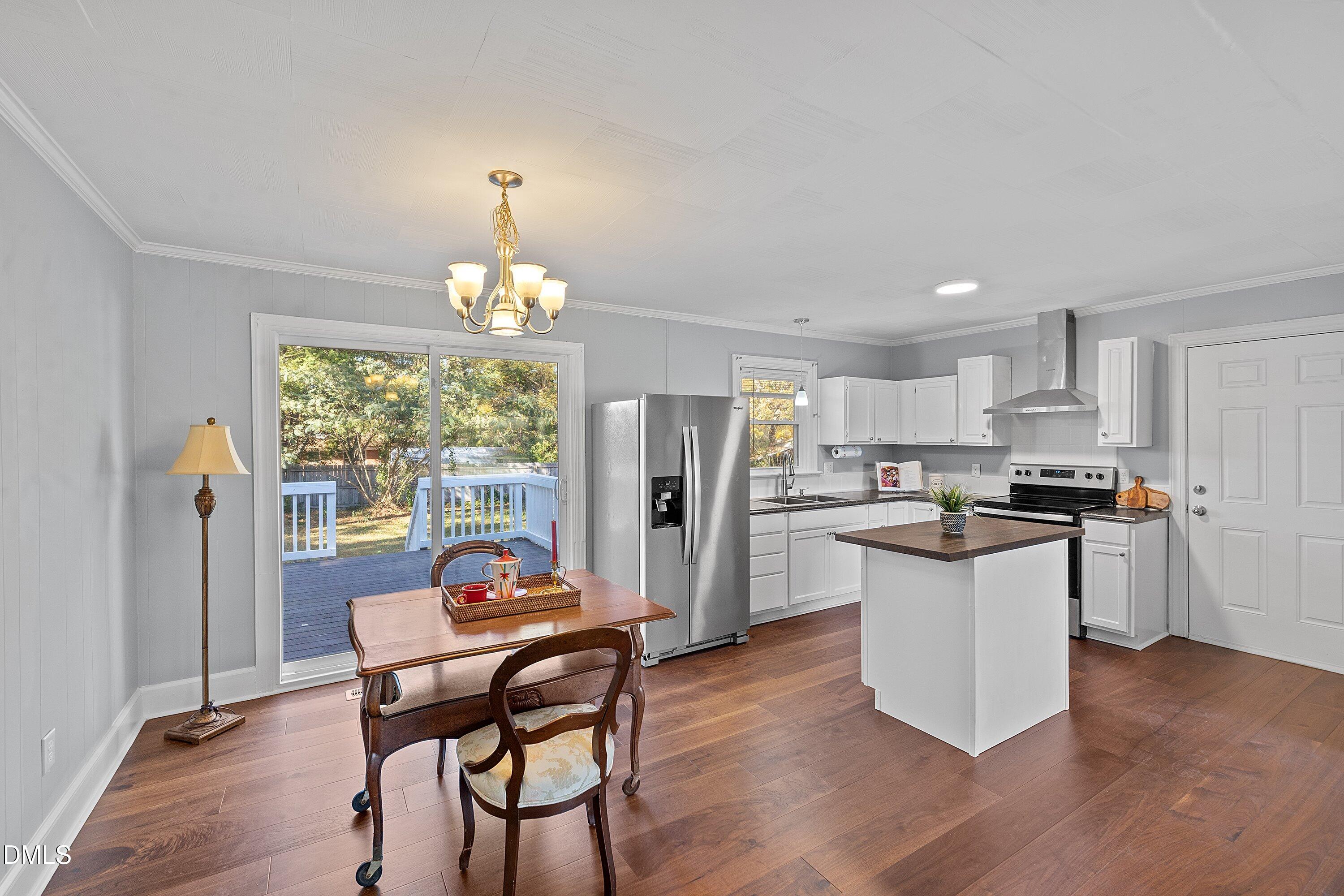 506 West Branch Street Spring Hope, NC 27882 - Photo 14 of 42 a kitchen with stainless steel appliances granite countertop a stove top oven a refrigerator a dining table and chairs with wooden floor