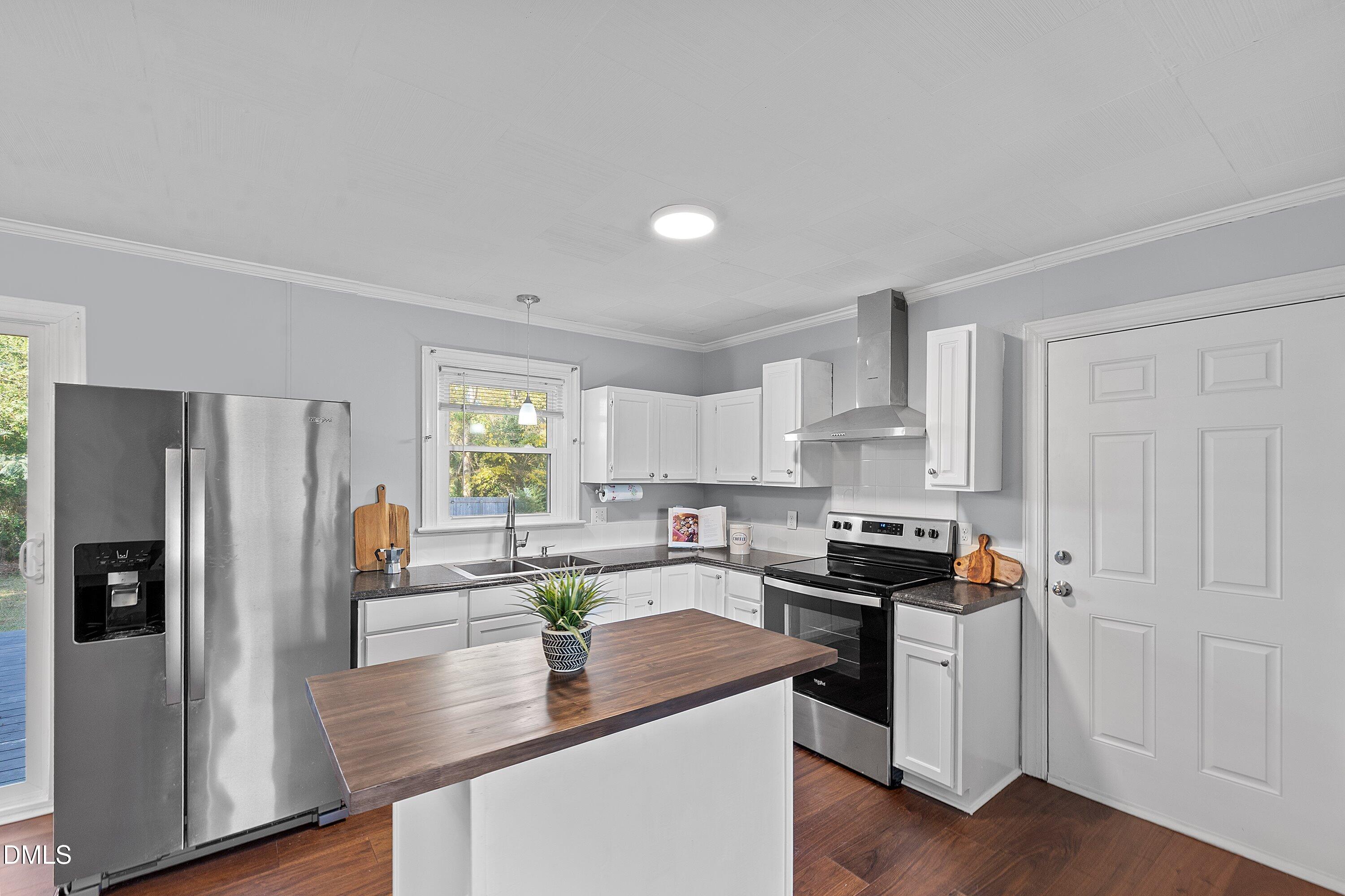 506 West Branch Street Spring Hope, NC 27882 - Photo 16 of 42 a kitchen with stainless steel appliances granite countertop a refrigerator a stove a sink dishwasher and white cabinets with wooden floor
