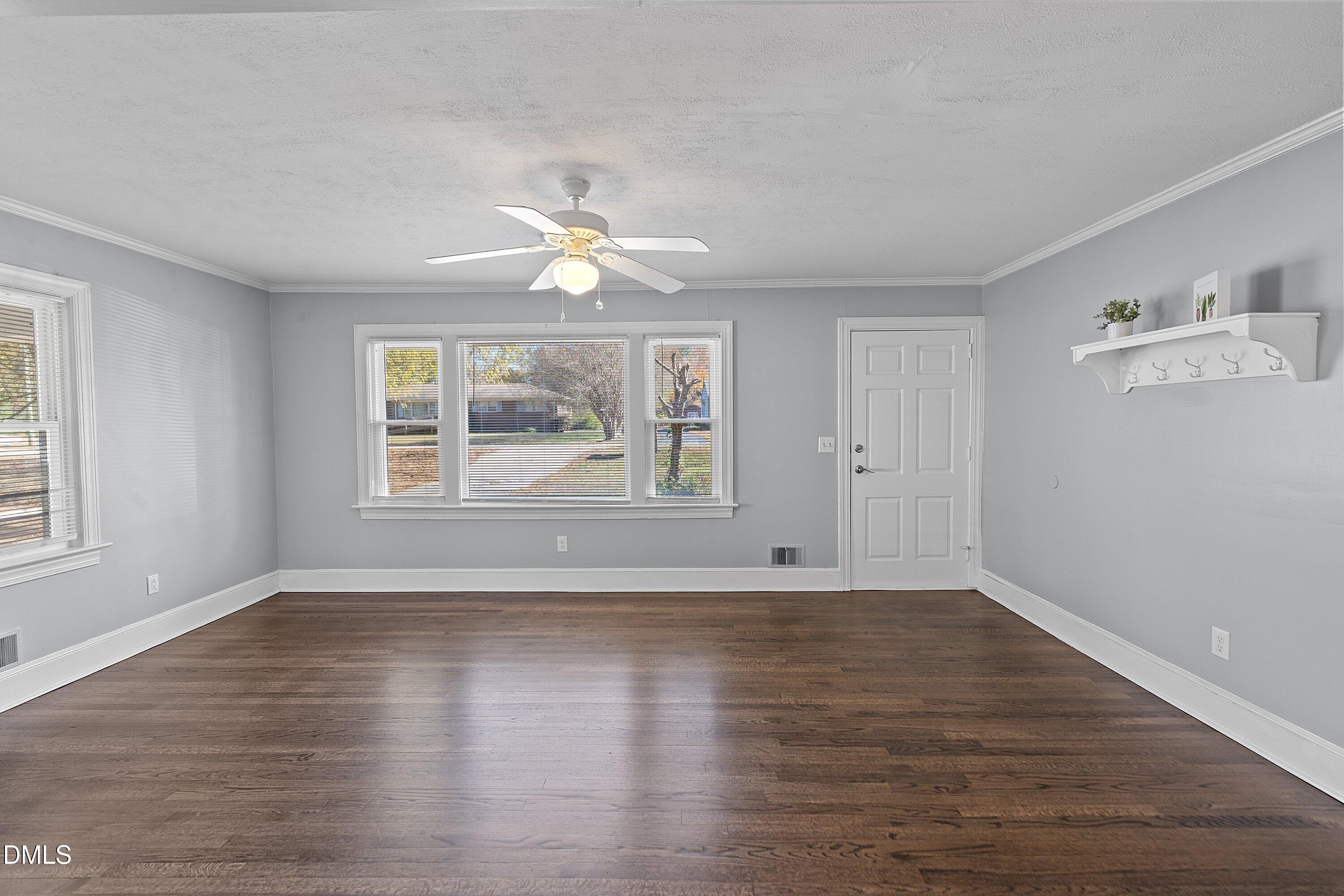 506 West Branch Street Spring Hope, NC 27882 - Photo 10 of 42 an empty room with wooden floor chandelier fan and windows