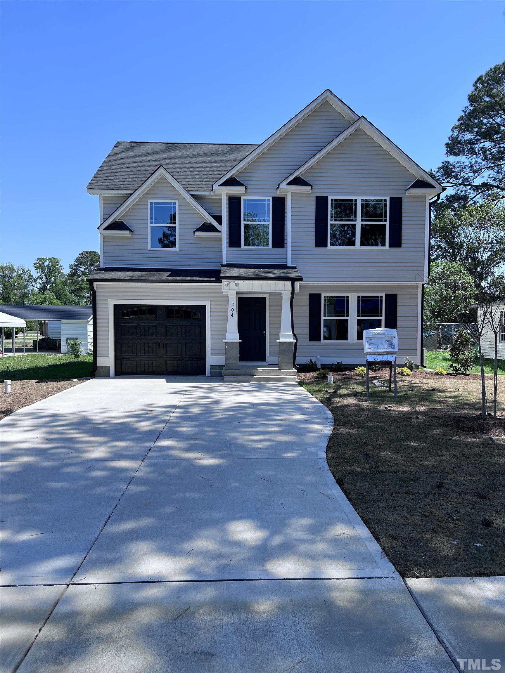 a front view of a house with yard and parking