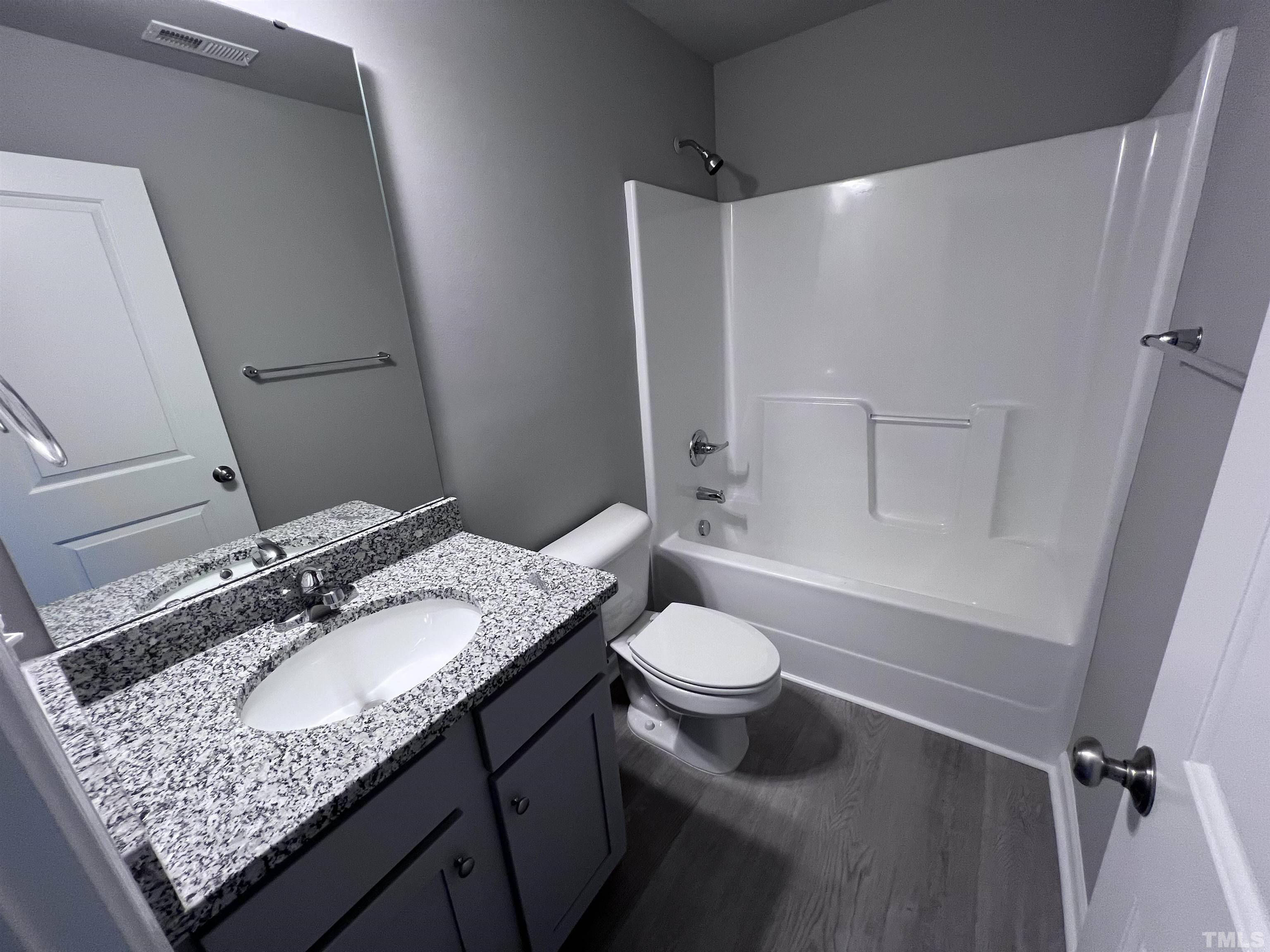 204 West Main Street Micro, NC 27576 - Photo 14 of 14 a bathroom with a granite countertop sink toilet and shower