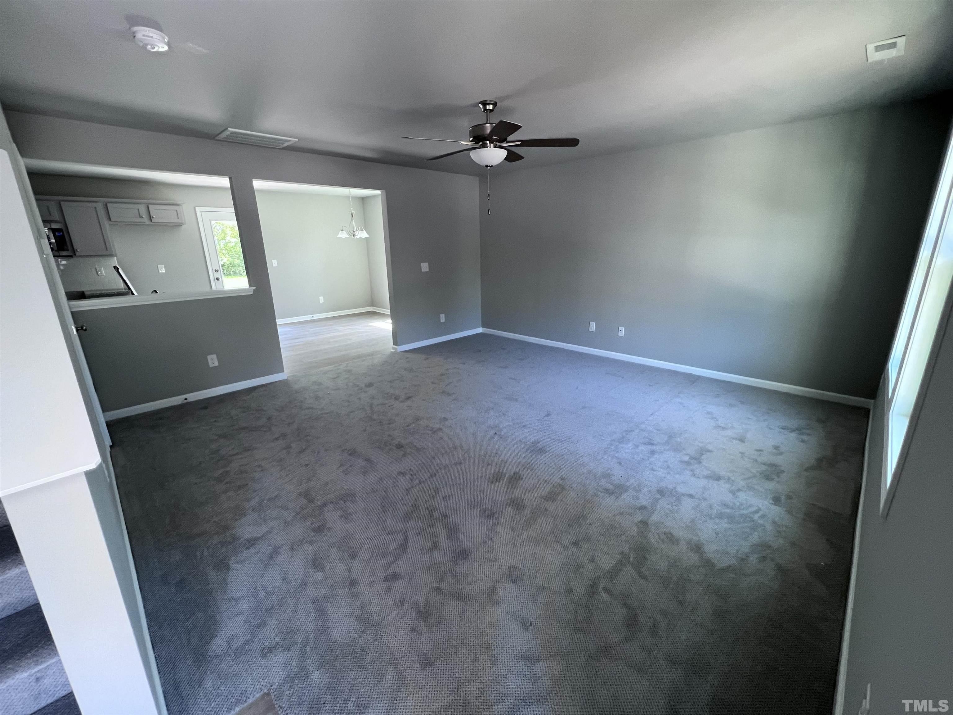 204 West Main Street Micro, NC 27576 - Photo 4 of 14 an empty room with a fireplace and wooden floor
