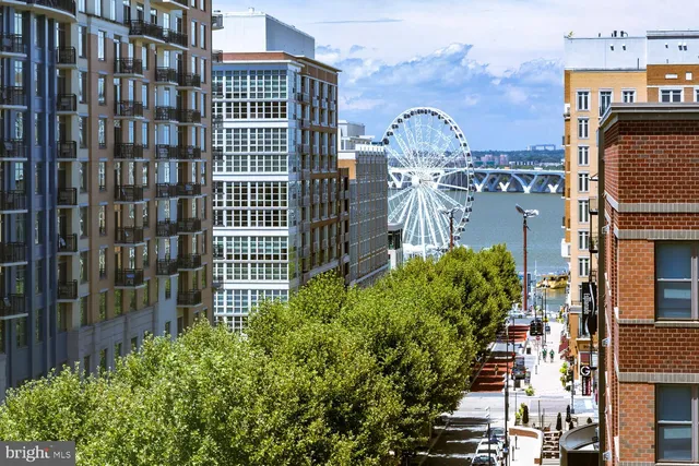 a living room with stainless steel appliances kitchen island granite countertop furniture a rug and a view of kitchen