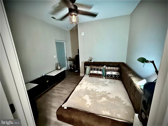 a view of a hallway to a livingroom with wooden floor and a chandelier